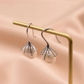Irregular freshwater pearl earrings in silver wire cage on gold stand and silk background - White Baroque Pearl