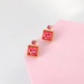 Detail of square pink crystal earrings with faceted stone in a gold setting - Rose Red