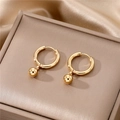 Macro view of gold hoop earrings with smooth bead pendants on premium champagne silk - Ball Pendant Style / Gold Ball Pendant