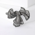 Broche de lazo vintage plateado con cristales gris oscuro en soporte minimalista blanco - Plateado