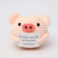 Close-up of pink handmade crochet pig holding an inspirational English slogan card - Pink Pig with Positive Card