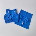 Detail of bright blue seamless yoga set featuring cross-strap bra and scrunch butt shorts - S / Blue