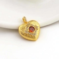 Detail of a gold heart pendant featuring a central red gem and white zircon accents - Golden Red Gemstone Heart (03)