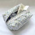 Inside view of a large capacity quilted floral makeup bag with blue flower patterns - Blue