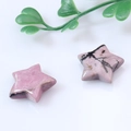 Pink and black natural star-shaped stone pendants for jewelry making on white background - Rhodonite