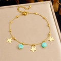 Gouden zeester armband met turquoise kralen op een beige sieradendoosje - Gouden Zeester Turkoois Stijl (B1625)