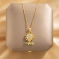 Elegant gold sunflower necklace with white zircon center and green gem leaves on display - Sunflower