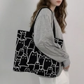 Detail of minimalist black canvas tote bag with white cat line art illustrations - Black