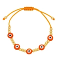 Detail of adjustable orange braided bracelet with golden beads and evil eye charms - Orange