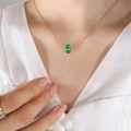Collana a catena dorata con ciondolo quadrato in gemma verde indossata da una modella - Verde/Maggio