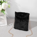 Minimalist black faux fur crossbody bag with a delicate gold chain strap on grey fabric - Black