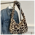 Detail shot of leopard print faux fur shoulder bag texture on blue denim background - Khaki