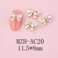 Macro detail of 11.5x8mm bow-shaped nail art jewelry with heart rhinestones on pink nails - Gold Base Moon White (AC20)