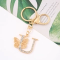 Detail of gold letter U keychain with sparkling crystals and a butterfly charm decoration - Letter U