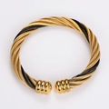 Detail of twisted gold and black steel cable bracelet with spherical metal caps - Intertwined Gold and Black
