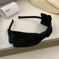 Vista detallada de una elegante diadema de tela negra con lazo sobre un fondo minimalista - Negro