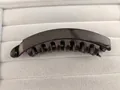 Detailed close-up showing the curved teeth design of the glossy banana hair clip for women - Bright Black