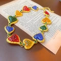 Collier vintage doré avec gemmes de cœur multicolores posé sur une page de livre ancien - 28# Collier - Collier de pierres précieuses en résine en forme de coeur coloré