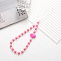 Rosa und weiße Handy-Perlenkette mit Herzanhänger auf strukturiertem Hintergrund - Handykette / Rosenrot (K2927)