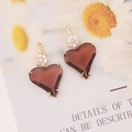 Close-up of wine red heart pendant earrings with gold floral studs and cubic zirconia - Coffee