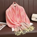 Scialle jacquard rosa e oro con motivi paisley e nappe decorative appeso su una stampella - Rosa Oro Motivo Paisley