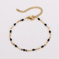 Dettaglio del bracciale a catena dorata con maglie ovali in smalto nero e chiusura - Oro + Smalto Nero