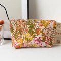 Détail d'une trousse à maquillage fleurie avec fermeture éclair dorée et textile tissé - Jungle Prospère Moyen