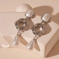 Detail of silver drop earrings with geometric rings and waterdrop pearls on marble stones - Silver Geometric Interlocking Water Drop Pearl Style (WE1800)