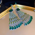 Détail macro de boucles d'oreilles paon émeraude avec strass brillants et pompons - 18# Tige en argent - Vert - Style paon