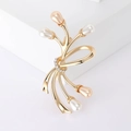 Spilla a fiocco dorata con perle color champagne e strass brillanti su fondo bianco - Oro