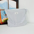 Detail view of a white canvas tote bag with black polka dots and a small branded label - White Polka Dot