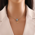 Close-up of golden necklace featuring a blue evil eye bead and a letter J pendant - Letter J (N1339)