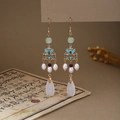 Macro detail of butterfly pearl tassel earrings with green drop pendant and gold frame - E6423 (Gold Butterfly/Pearl/Tassel/Drop)