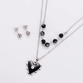 Nahaufnahme der zweilagigen Kette mit schwarzem Herzanhänger, Evil-Eye-Perlen und Steckern - Stahlschwarz