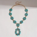Vue détaillée du collier bohème en bronze avec résine turquoise et pendentif fleur ajouré - Collier-Bleu