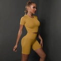 Close-up of seamless mustard yellow high-waisted fitness shorts with knitted texture - Yellow