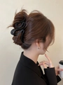 Vista laterale della modella con un mollettone nero opaco a onde da 13cm nei capelli - Nero