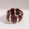 Detail van bordeauxrode acryl schakels en gouden metalen afstandhouders op een armband - Donkerrood