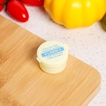 Detail view of portable mini round sauce container with yellow lid in a kitchen setting - Alphabet / Beige