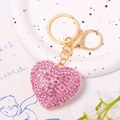 Pink heart keychain with glittering rhinestones and gold lobster clasp on white tray - Polka Dot Disc Pink Heart