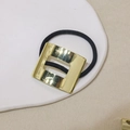 Minimalist black hair tie with polished gold square metal buckle on a white tray - Hollow Square - Gold