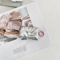 Detail van zilveren gewatteerde oortelefoonhoes met roze haak op mode tijdschrift - Hart Zilver