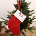 Red knit Christmas stocking with white cuff featuring a red embroidered letter P - Letter P