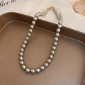 Collier de perles grises élégant avec fermoir doré posé sur un plateau de luxe - 8mm / Gris