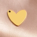 Polierter goldener Herzanhänger auf Seidenstoff, minimalistischer Edelstahlschmuck - Gold