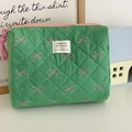 Detail of green quilted makeup bag with pink bow prints and stylish woven zipper pull - Green Fruit Bow [Handbag]