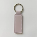 Detail shot of light pink rectangular PU leather keychain with silver metal ring and stitching - Violet
