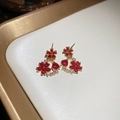 Detail of 18k gold plated floral stud earrings with red and clear gemstones on tray - Silver Needle Earrings - Red