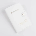 Detailed macro view of white PU leather passport cover with gold airplane stamp and button - Airplane Pattern / White