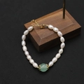 Elegant natural rice pearl bracelet with a green jade bead and gold lobster clasp - Single Emerald Pearl Bracelet